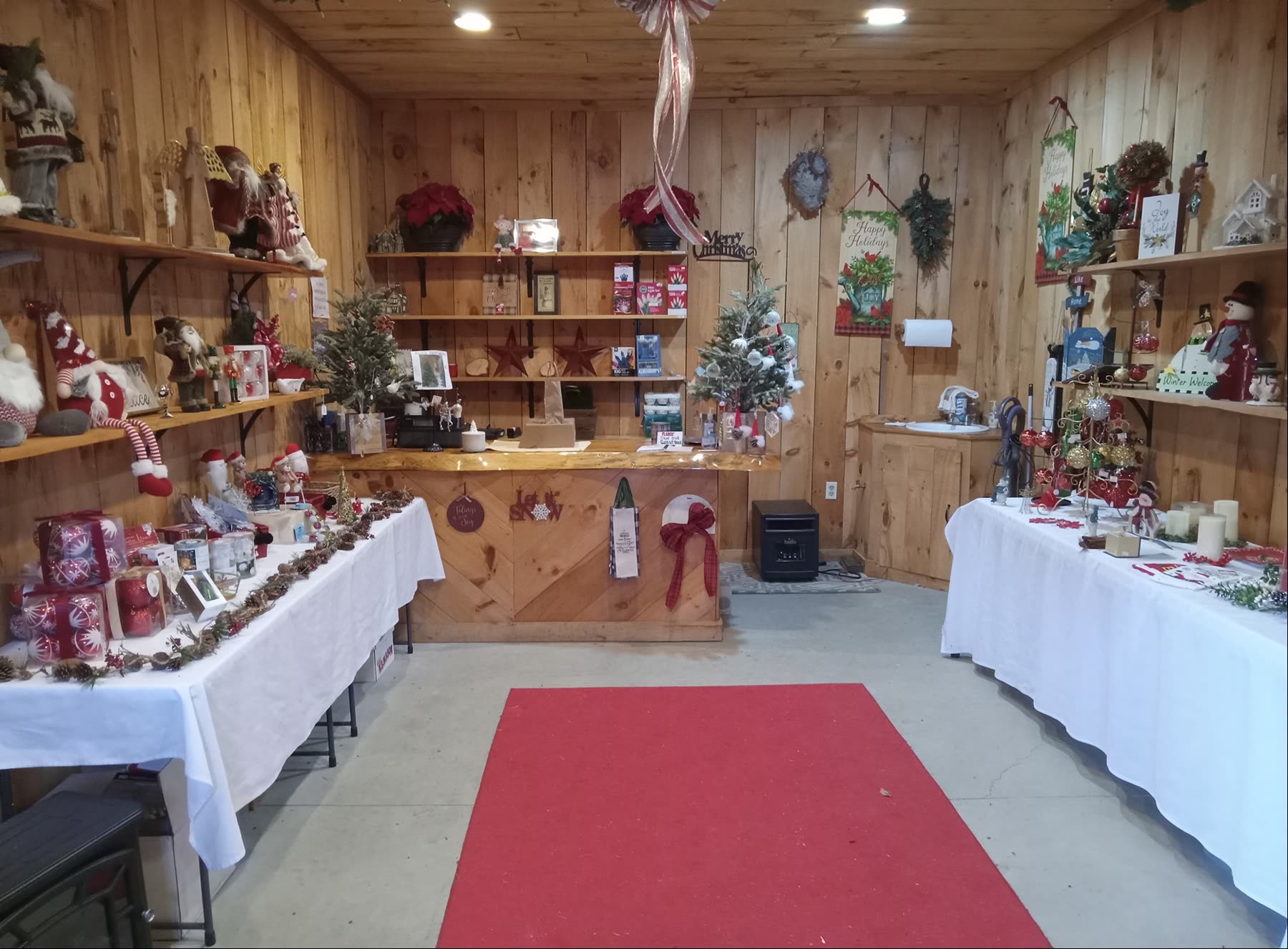 Inside the farm shop: wooden walls, shelves of ornaments and a red carpet